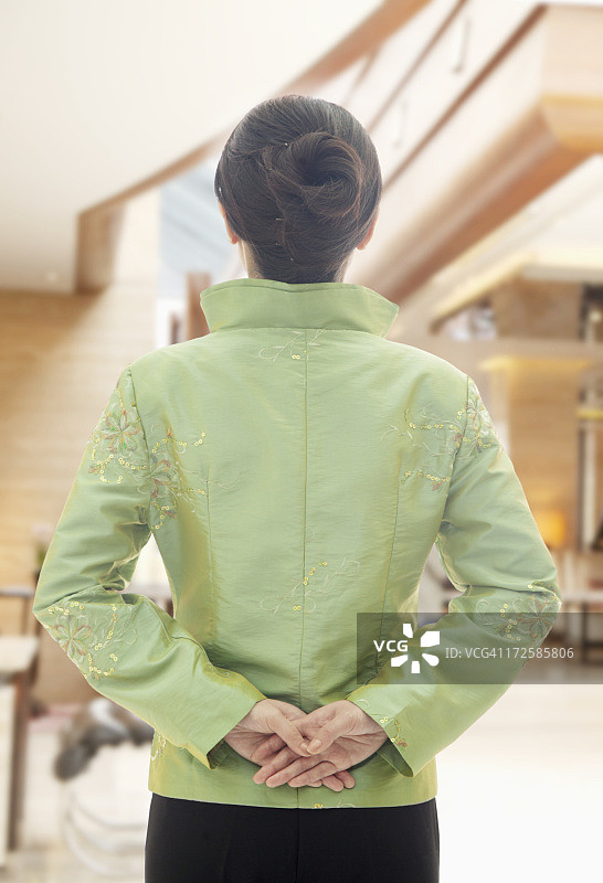 身穿中国传统服装的餐厅/酒店女服务员（背面视角）图片素材
