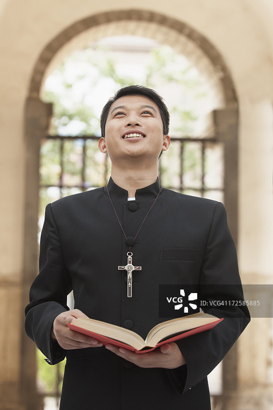 年轻的牧师在门口仰望天空图片素材