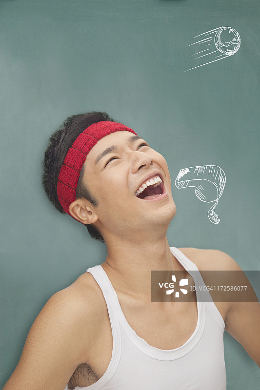 年轻的运动型男人在画有图画的黑板前图片素材