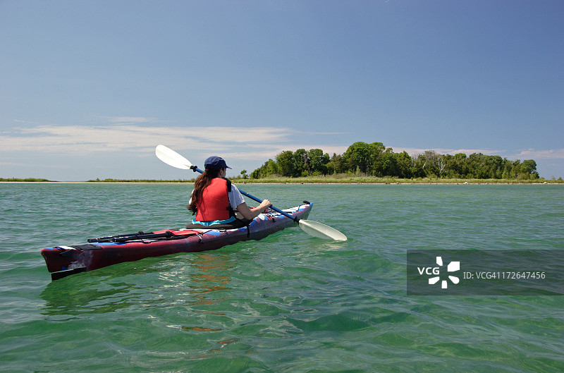 女人在阳光明媚的日子里划皮划艇图片素材