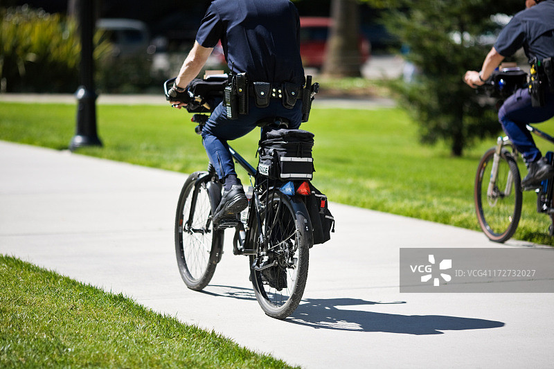 两名警察骑自行车在公园巡逻图片素材