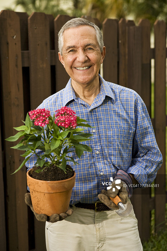手拿花盆和小铲子园艺的老年男人图片素材