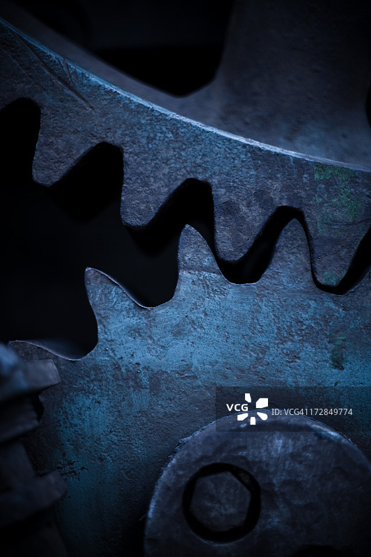 蓝色滤镜上的铜制齿轮图片素材