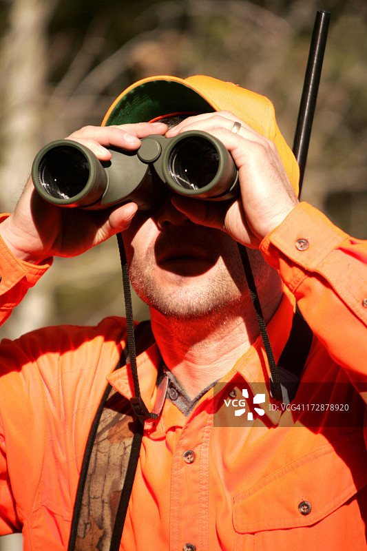身穿猎装，用双筒望远镜观察的男人图片素材