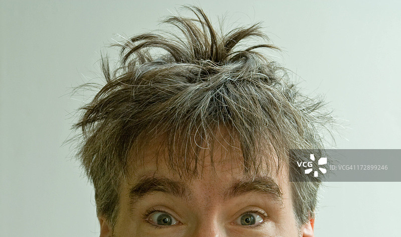白色背景上，眼神夸张，头发蓬乱的男子图片素材