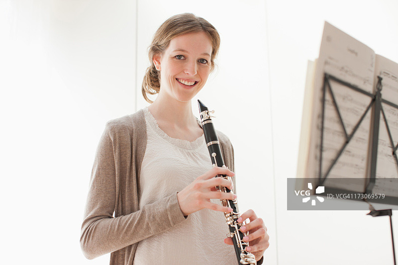 微笑的女人手持单簧管图片素材