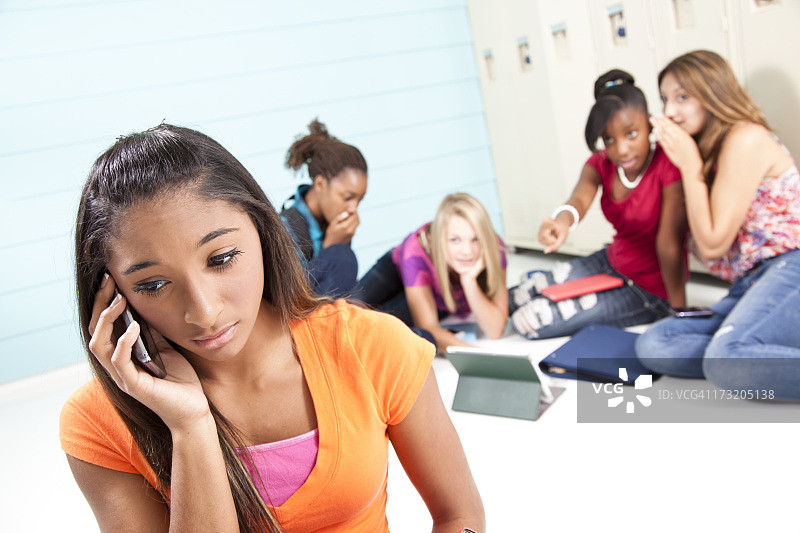 少女们在聊天，使用手机。校园霸凌，高中，排斥，谈话。图片素材