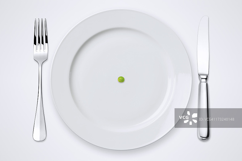 盘中的一颗青豆，带裁剪路径的餐桌摆设图片素材