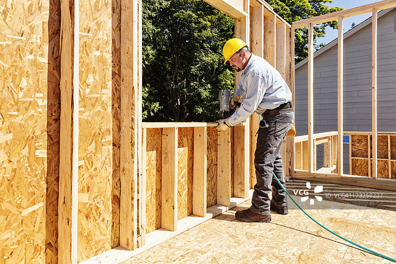 手持射钉枪的建筑工人图片素材