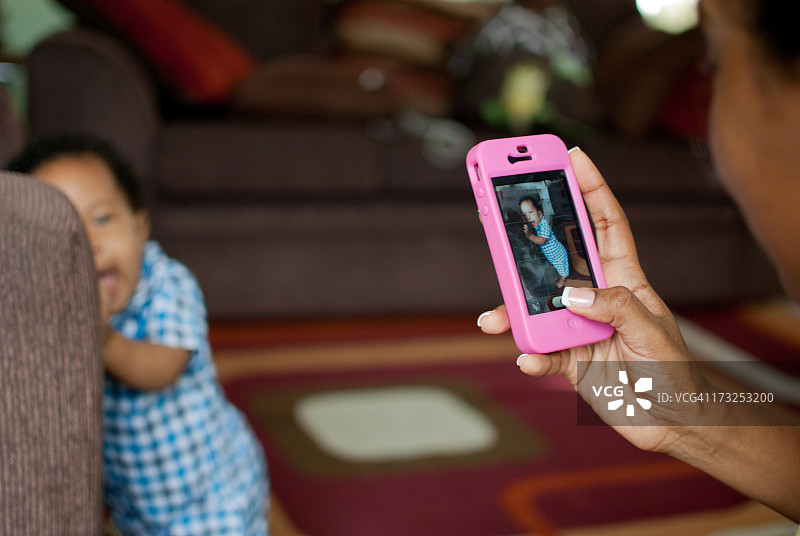 母亲给儿子拍照。图片素材