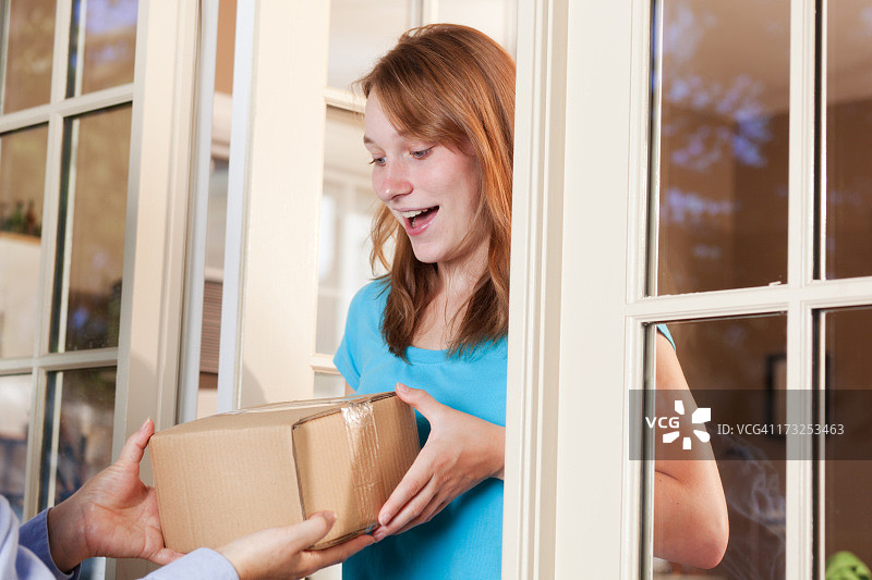 年轻女子从快递服务处收到包裹图片素材
