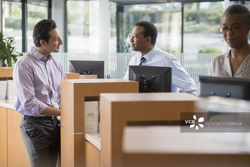 客户与银行职员在柜台交谈图片素材