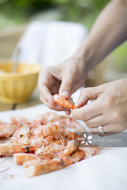 女人在桌旁清洗对虾图片素材