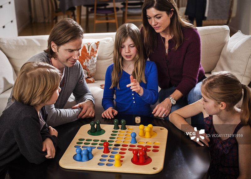 一家五口在桌旁一起玩飞行棋图片素材