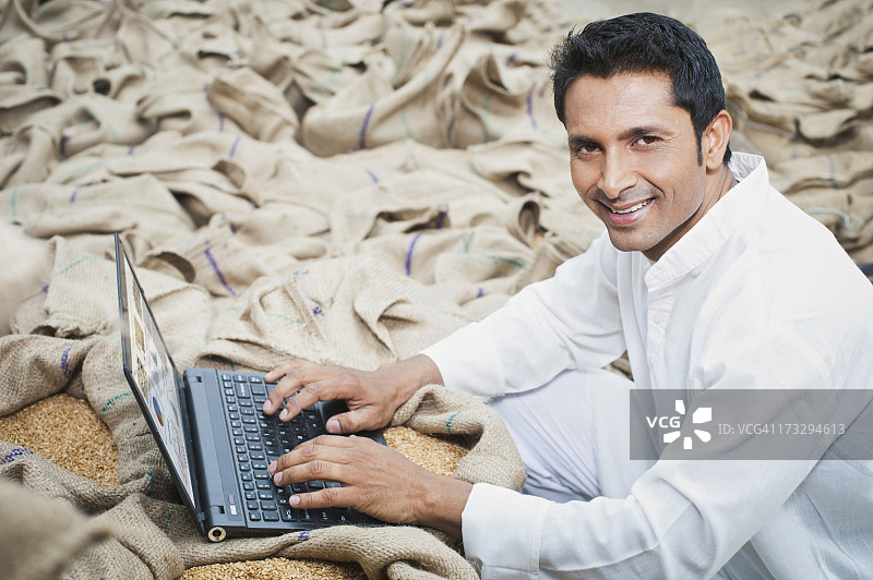 在印度哈里亚纳邦粮食市场用笔记本电脑工作的男人图片素材