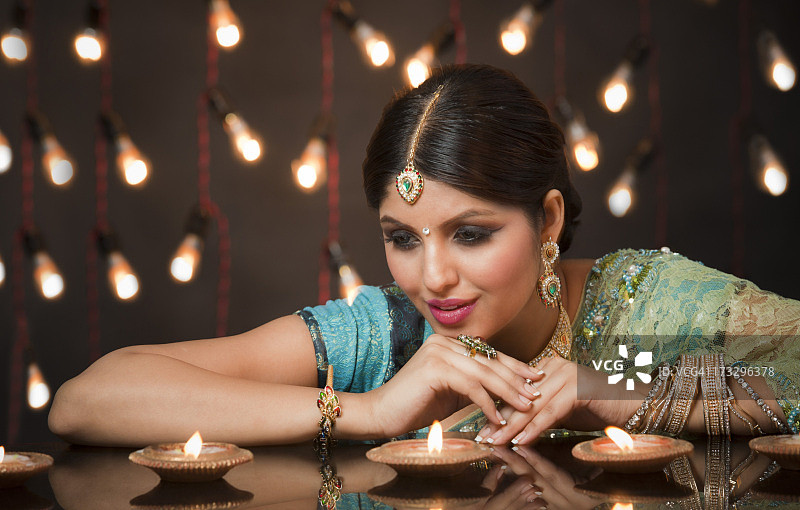 女人看着排灯节上的油灯图片素材
