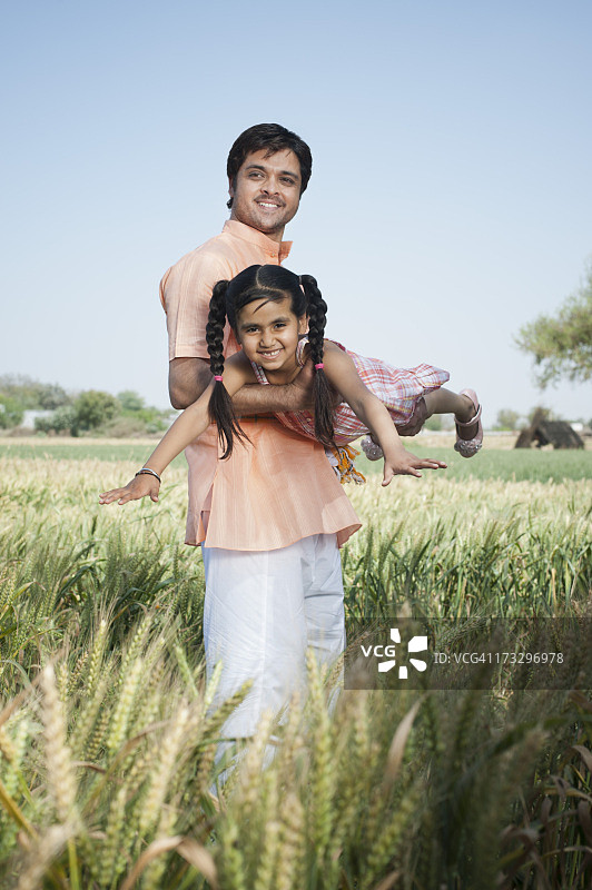 农民在印度哈里亚纳邦索纳的田野里抱着他的女儿图片素材
