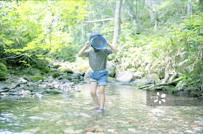 在小溪里玩耍的小男孩图片素材