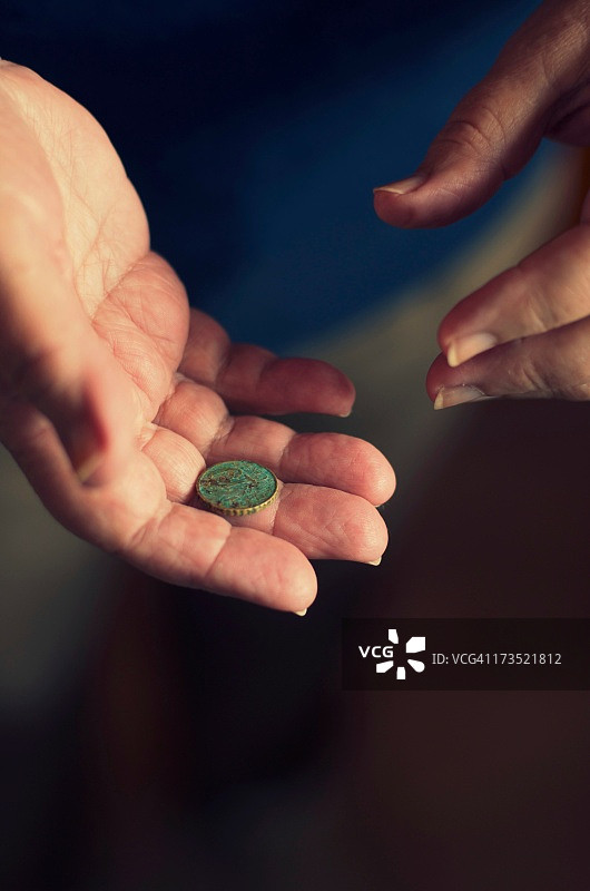 拿着旧的10欧分硬币的年长女人图片素材