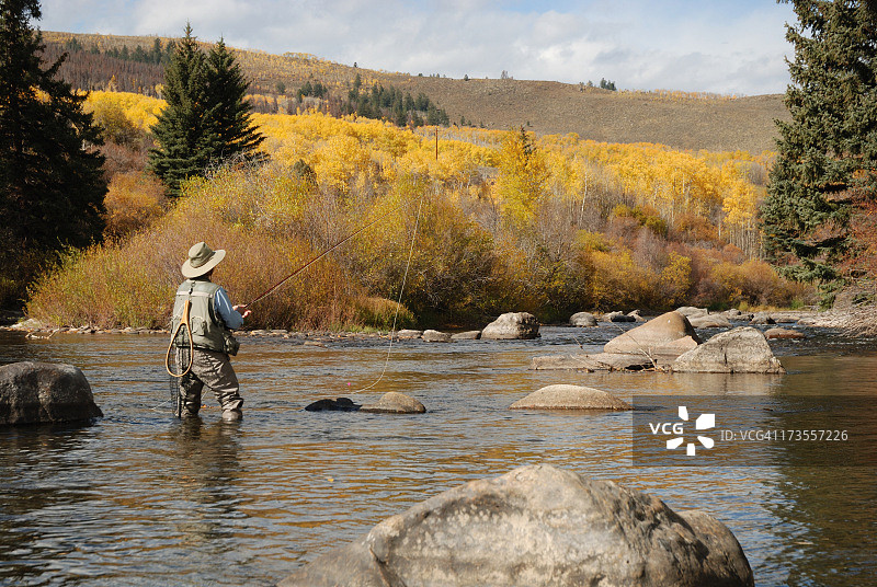 女性在河中飞蝇钓鱼的远景图像图片素材