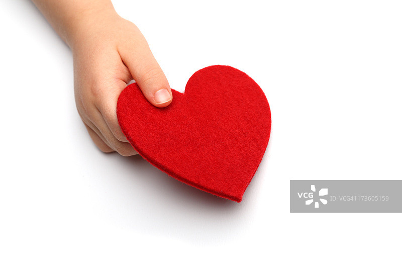孩子的手拿着毡制心形，白色背景图片素材