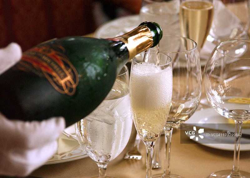 为优雅晚餐在高脚杯中倒入香槟图片素材