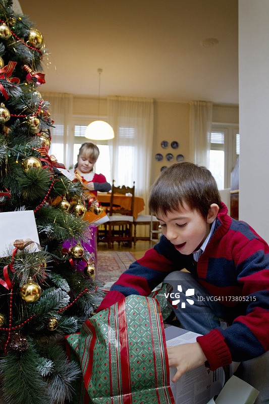 男孩检查圣诞礼物图片素材