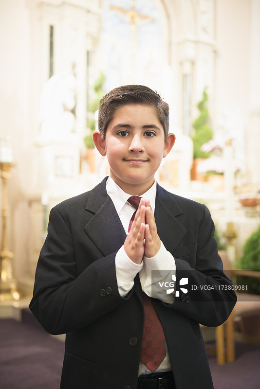 在教堂里双手合十的西班牙裔男孩图片素材