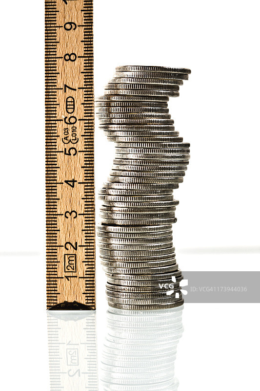 用尺子测量你的金钱观和一堆硬币图片素材