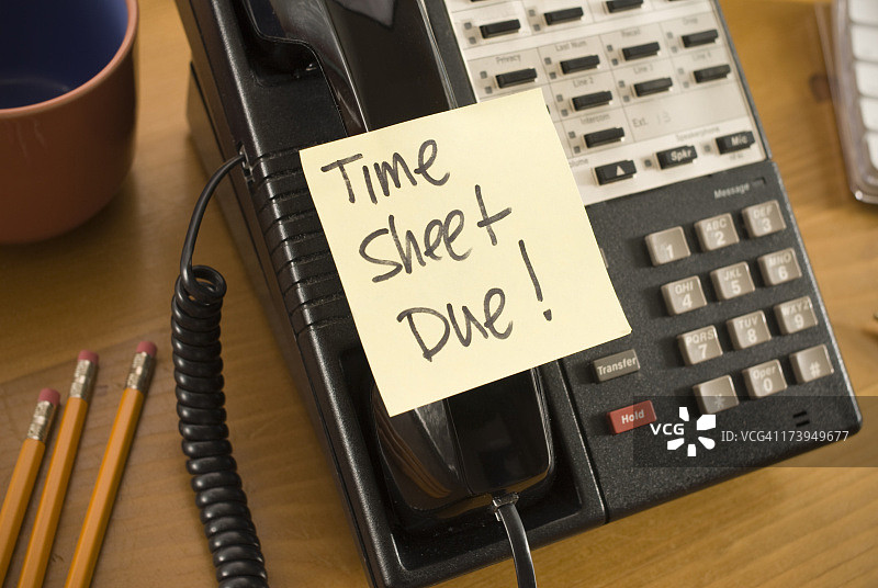贴在电话上的便签上写着到期时间表图片素材