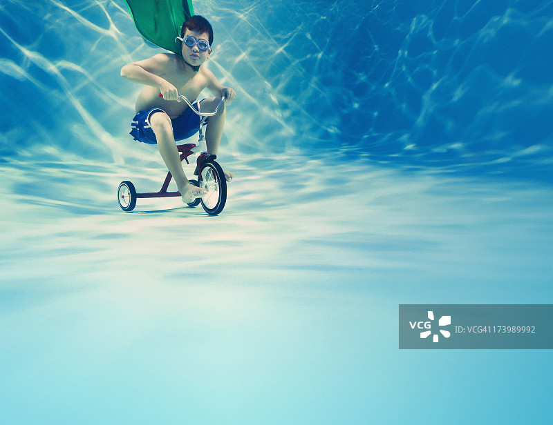 男孩在水下骑三轮车图片素材