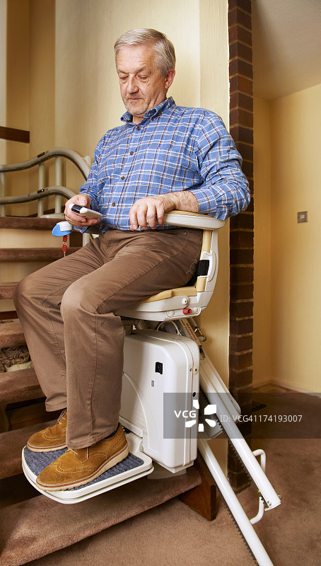 年长的男人乘坐楼梯升降机图片素材