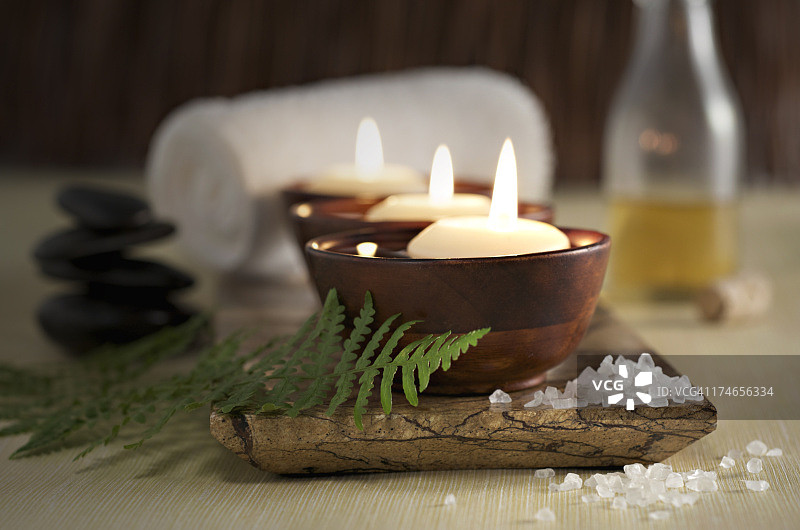 禅意SPA中的漂浮蜡烛、按摩石和精油图片素材