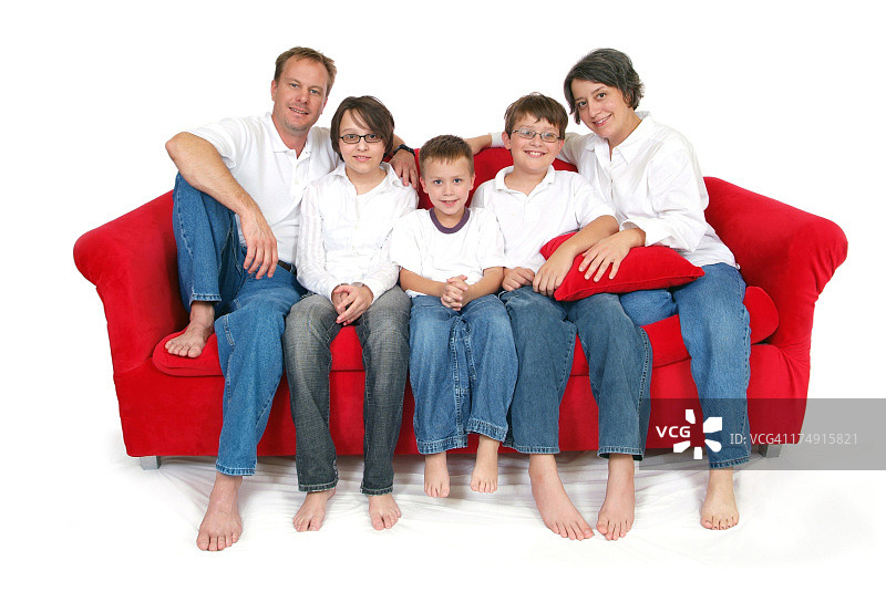 幸福的五口之家坐在红色大沙发上图片素材
