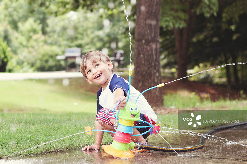 在洒水器中享受夏季乐趣图片素材