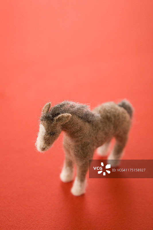 红色纸上的毛毡玩具马图片素材
