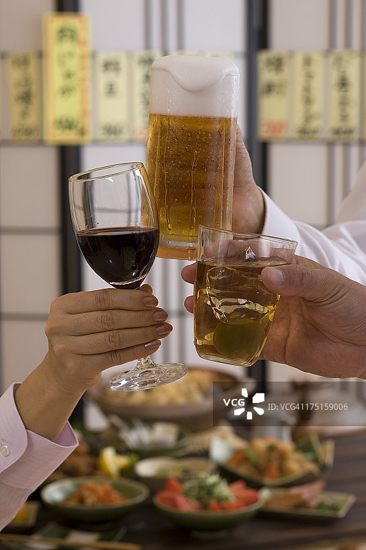 在日式酒吧用各种饮品互相敬酒的三个人图片素材