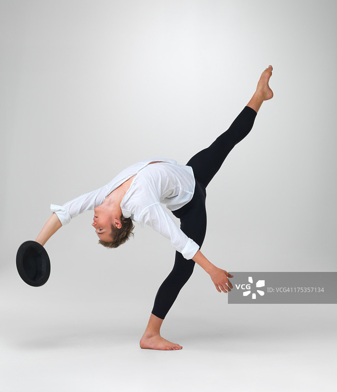 手持帽子表演独特舞步的男性芭蕾舞演员图片素材