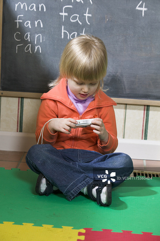 女孩在学校里看数码相机图片素材