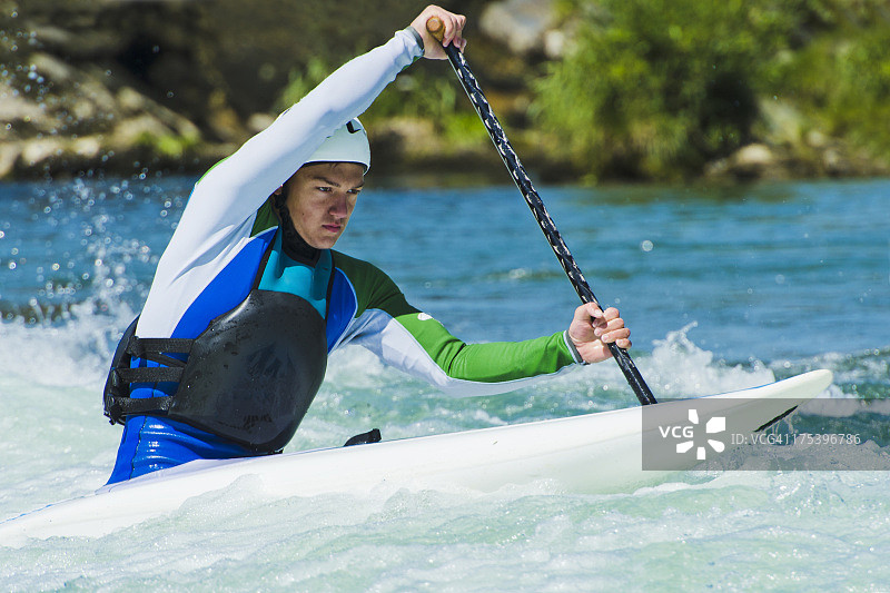 在激流中的年轻男性皮划艇运动员图片素材