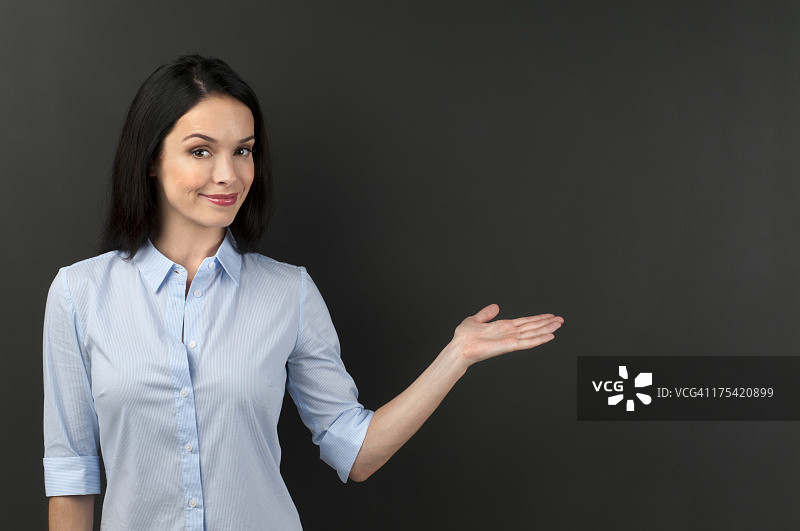 在黑板上展示东西的女人图片素材