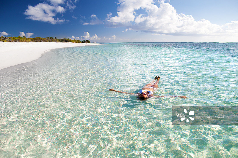 女人漂浮在加勒比海清澈的海水中图片素材