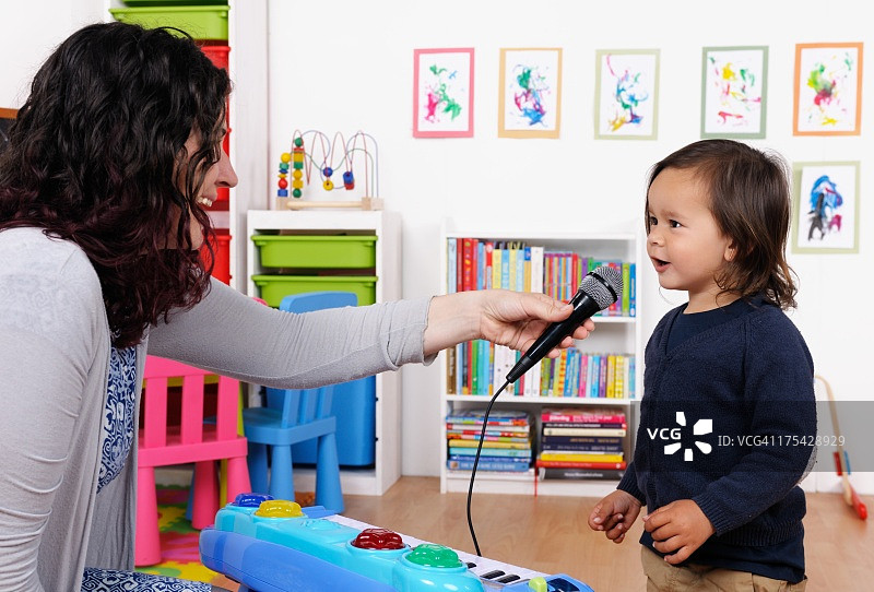 小男孩在保姆拿着麦克风时唱歌图片素材