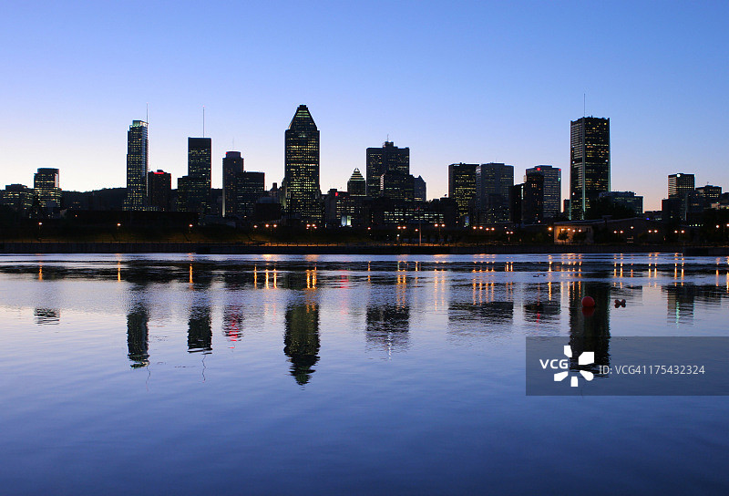 日落时分水中倒映的蒙特利尔天际线图片素材