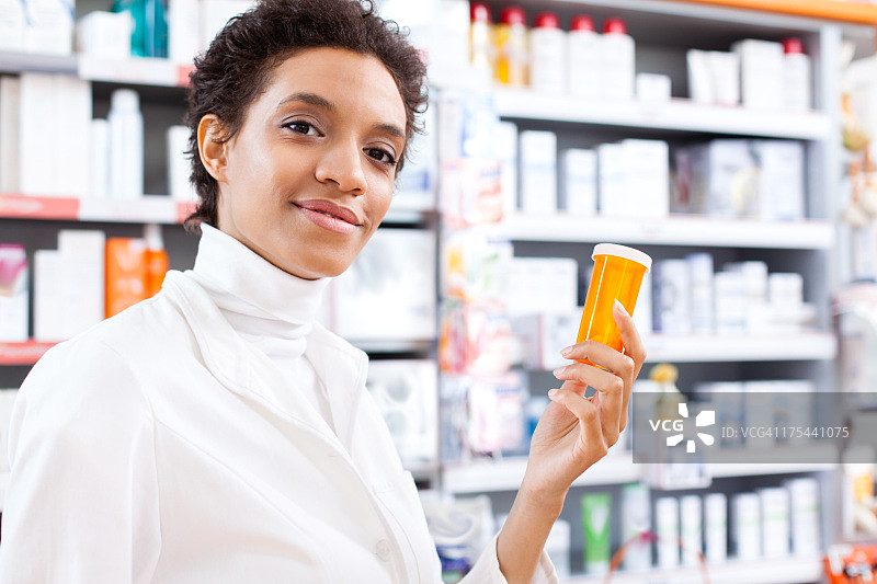 拿着药瓶的年轻女药剂师图片素材