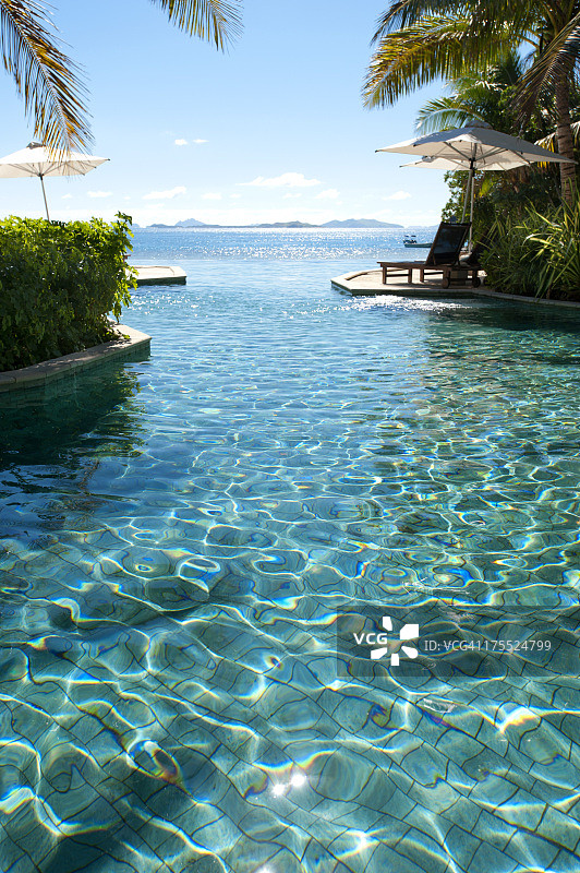 泳池边的日光浴躺椅，可观赏海景图片素材