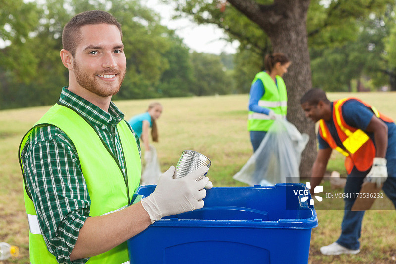 快乐的志愿者与社区服务团体一起捡垃圾/回收图片素材
