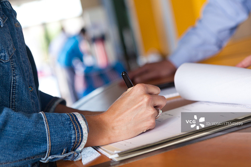 女子在活动中填写登记表图片素材