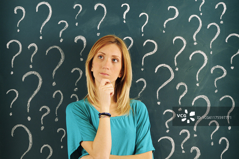 沉思的女人，黑板上画着问号图片素材