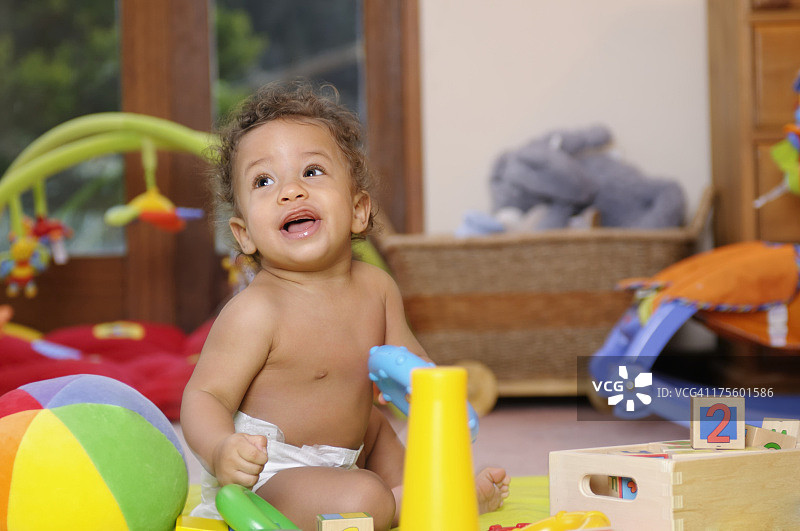 快乐的混血宝宝玩多色圆环图片素材